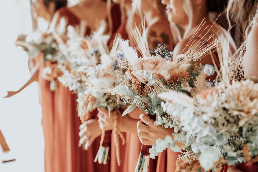 Bridesmaids holding flowers in a row