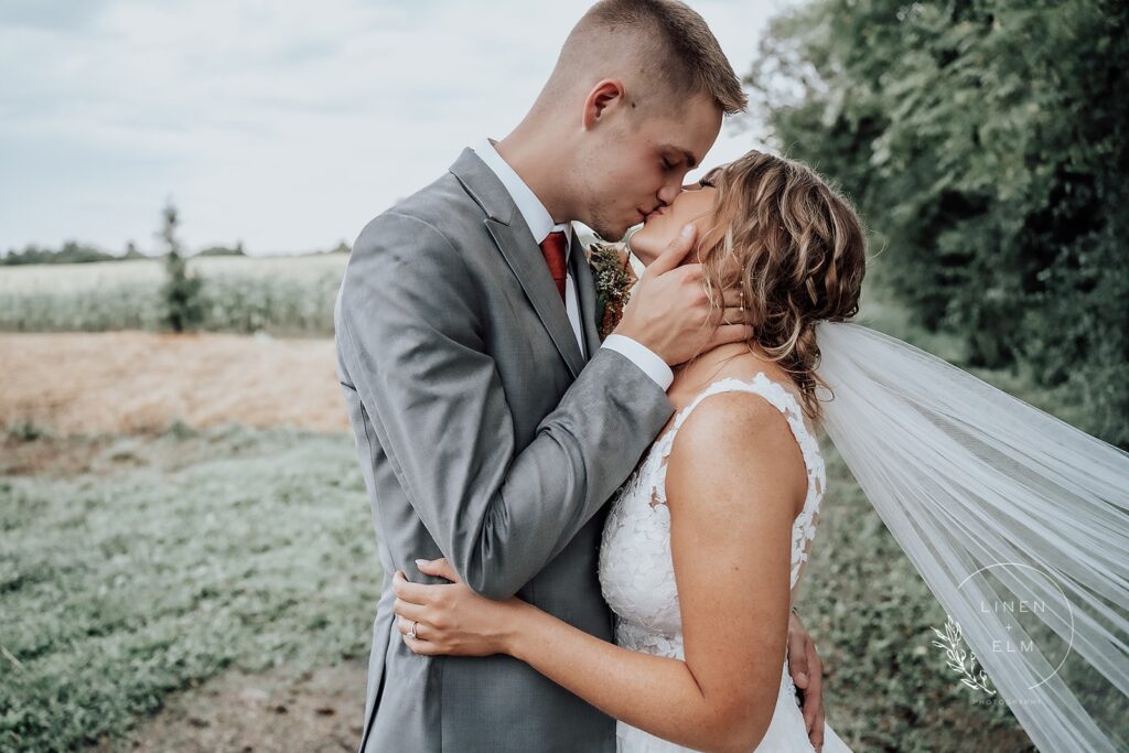 Wedding couple kissing outdoors after ceremony