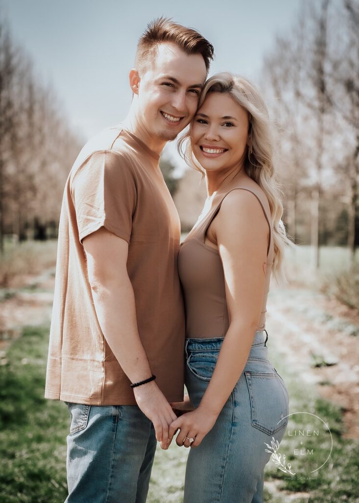 Couple facing each other touching foreheads looking at the camera smiling