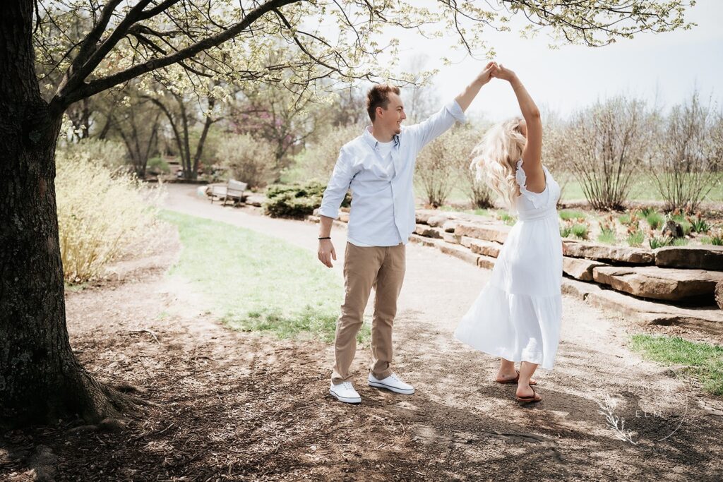 Engagement photography couple twirling in park under a tree