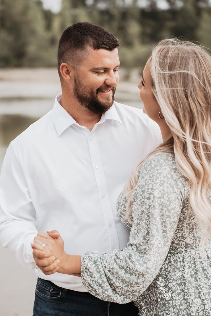Man looking fondly at his fiancé during slow dance in Ohio park, Bright Rustic Engagement Session Dayton Ohio