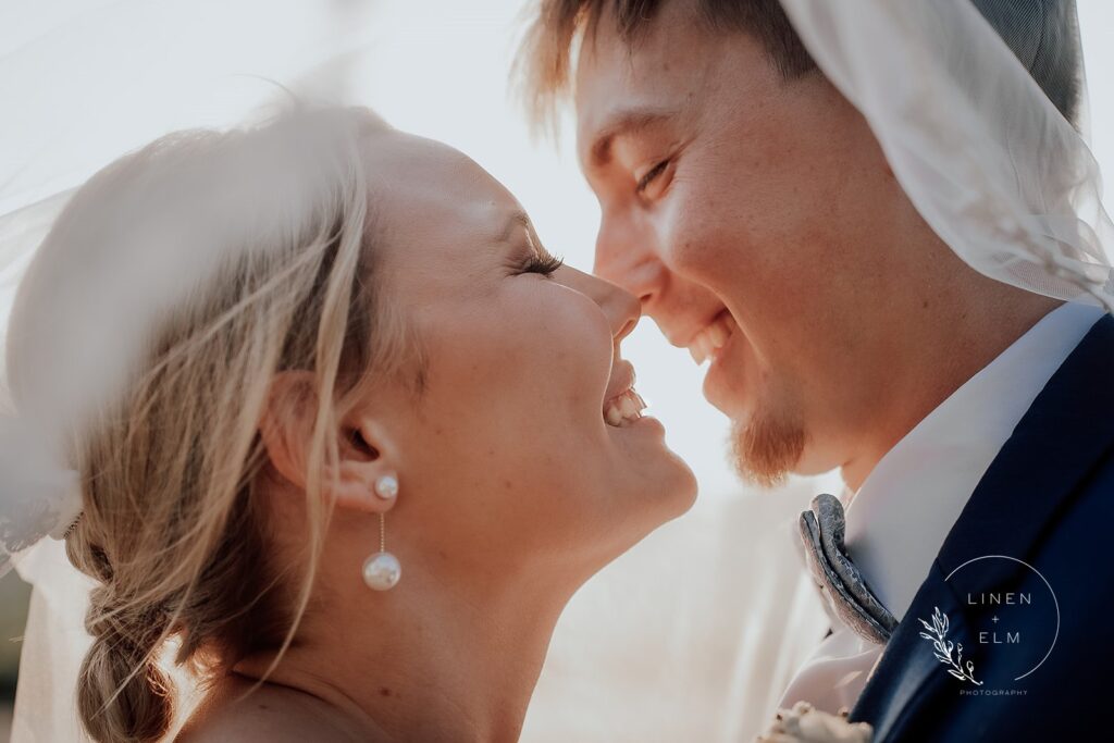 Under the veil bride and groom portrait at sunset