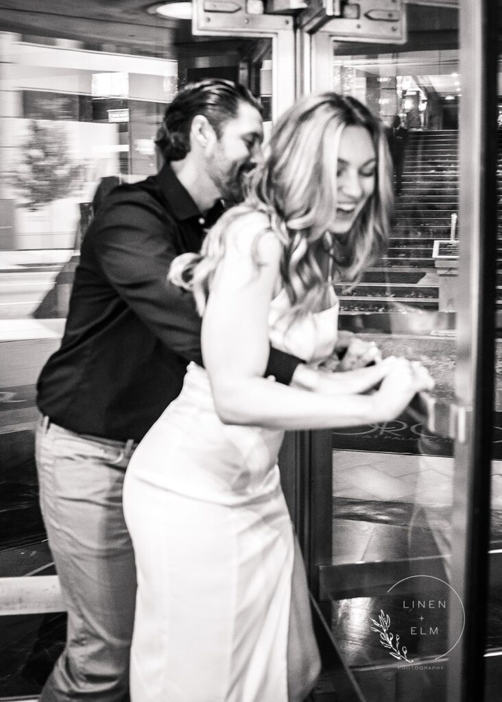 Couple Having Fun In Revolving Door At Hilton Netherland Hotel Cincinnati Engagement Photographer