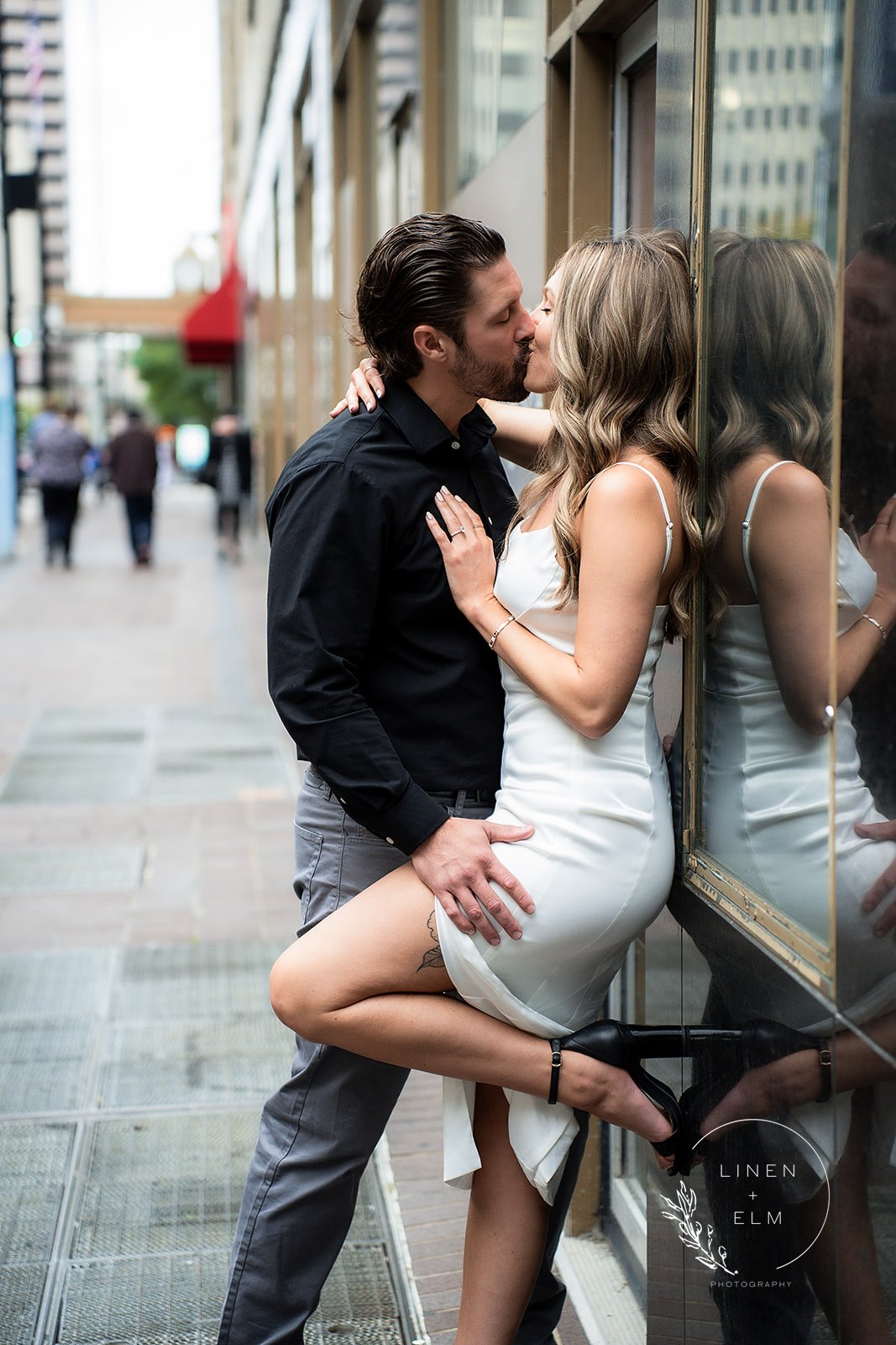 Couple kissing in front of Hilton Netherland Plaza Hotel engagement photography