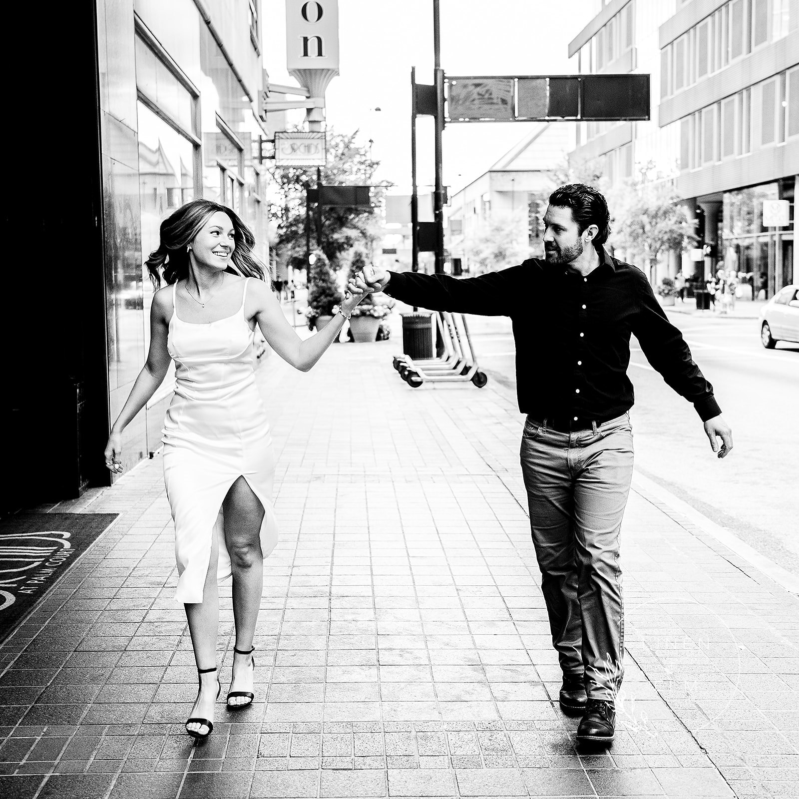 Black and white image of couple walking holding hands engagement photo